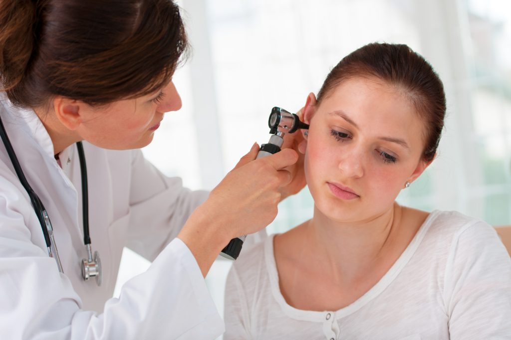 Doctora realizando revisión auditiva a paciente